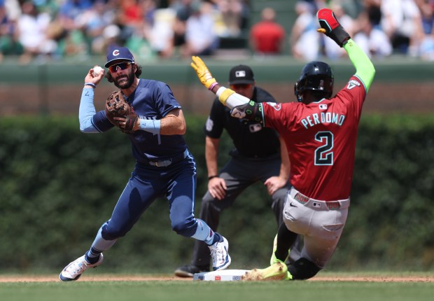 Cubs shortstop Dansby Swanson forces out Diamondbacks shortstop Geraldo Perdomo (2) at second base before trying to complete a double play in the third inning on July 19, 2024, at Wrigley Field. (Chris Sweda/Chicago Tribune)