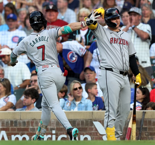 Arizona Diamondbacks outfielder Corbin Carroll (7) is congratulated by teammate Joc Pederson (3) after Carroll hit a 2-run home run in the fifth inning of a game against the Chicago Cubs at Wrigley Field in Chicago on July 20, 2024. (Chris Sweda/Chicago Tribune)