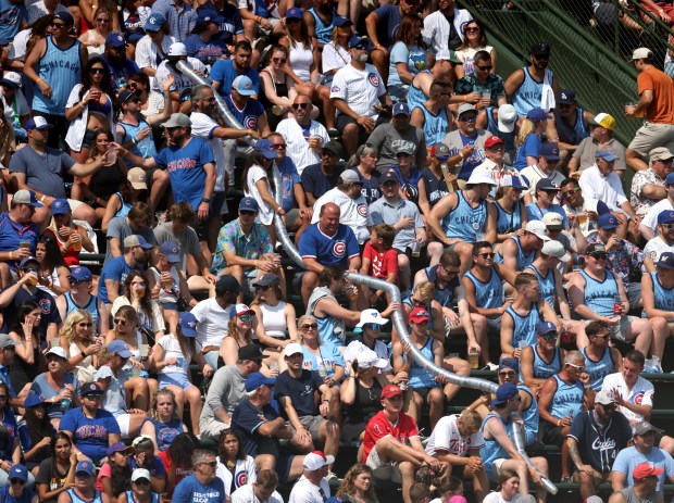 Fans in the bleachers build a plastic cup snake in the sixth inning on July 19, 2024, at Wrigley Field. (Chris Sweda/Chicago Tribune)