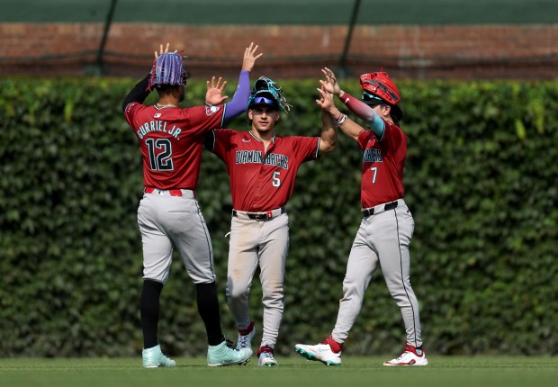 Diamondbacks outfielders Lourdes Gurriel Jr. (12), Alek Thomas (5) and Corbin Carroll (7) celebrate a victory over the Cubs on July 19, 2024, at Wrigley Field. (Chris Sweda/Chicago Tribune)