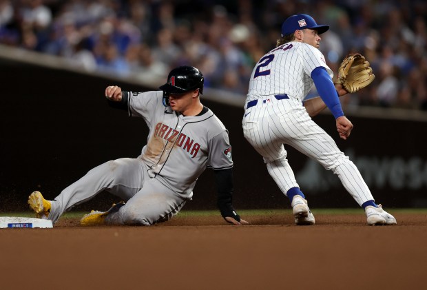 Chicago Cubs second baseman Nico Hoerner (2) waits for the ball as Arizona Diamondbacks designated hitter Joc Pederson steals second base in the 8th inning of a game at Wrigley Field in Chicago on July 20, 2024. (Chris Sweda/Chicago Tribune)