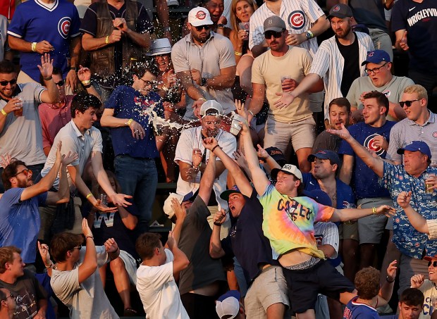 Beer is spilled as fans in the left field bleachers try to catch a ball that went for a 2-run home run for Arizona Diamondbacks outfielder Corbin Carroll in the fifth inning of a game against the Chicago Cubs at Wrigley Field in Chicago on July 20, 2024. (Chris Sweda/Chicago Tribune)