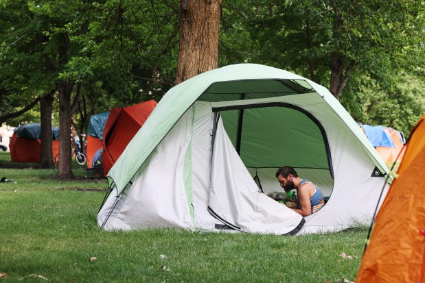 Salema Bowie sits in a tent at an encampment in the northeast corner of Humboldt Park, June 25, 2024, in Chicago. Bowie said he has stayed in a tent since the beginning of May. (John J. Kim/Chicago Tribune)