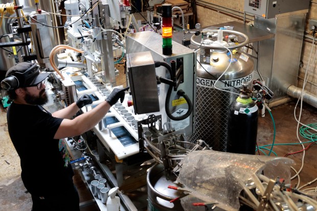 Justin Hignight operates a liquid nitrogen doser system at Dark Matter Coffee in Chicago. (Antonio Perez/Chicago Tribune)