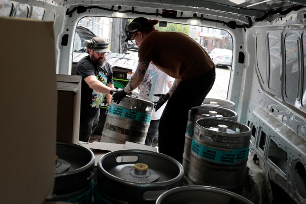 Head brewer and production manager Justin Hignight and brew assistant Collin Stewart load kegs of Dark Matter Coffee into a van for delivery, June 13, 2024. (Antonio Perez/Chicago Tribune)