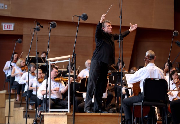 Giancarlo Guerrero, here as a guest conductor, leads the Grant Park Orchestra in works by Joan Tower and Dmitri Shostakovich at Millennium Park's Pritzker Pavilion on July 10, 2024. (Chris Sweda/Chicago Tribune)