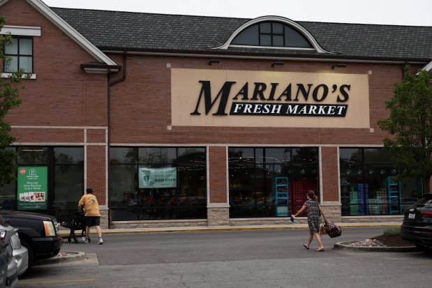 Shoppers walk to the entrance of Mariano's in the North Center neighborhood, one of the eight Chicago stores that Kroger and Albertsons plans to sell off in hopes of securing federal approval for their planned megamerger, on July 9, 2024. (Eileen T. Meslar/Chicago Tribune)