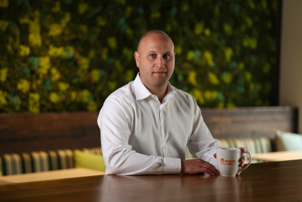 Grubhub CEO Howard Migdal sits at a table at its Loop headquarters in Chicago on July 16, 2024. (Eileen T. Meslar/Chicago Tribune)