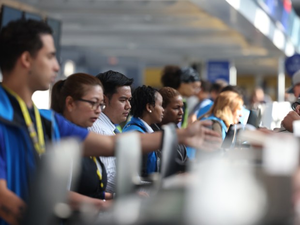 United Airlines staff work as passengers crowd the ticket counter as a global technology outage grounded many flights at Chicago's O'Hare International Airport Friday morning, July 19, 2024. (Antonio Perez/Chicago Tribune)