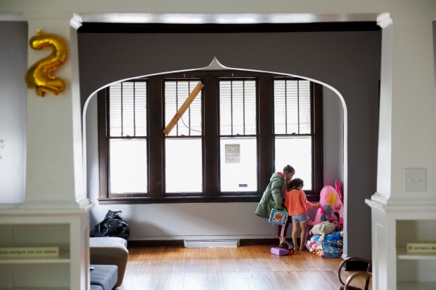 Haikmarys Moncayo, 8, left, and her sister Gabrielys Moncayo, 5, play near a window in their home in the 11500 block of South LaSalle Street in the West Pullman neighborhood on March 27, 2024, in Chicago. When Karina Fuentes toured the home in late February while still living in a shelter, she told her case workers she wouldn't move in because she felt it was dangerous and there wasn't a school or hospital nearby for her family. (Armando L. Sanchez/Chicago Tribune)