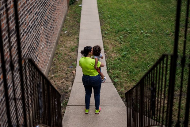 A migrant woman from Venezuela holds her 1-year-old son near their home in the Austin neighborhood, July 9, 2024. In June, while looking for an apartment with her son, she was sexually assaulted in an alley near Roseland Community Hospital. (Armando L. Sanchez/Chicago Tribune)