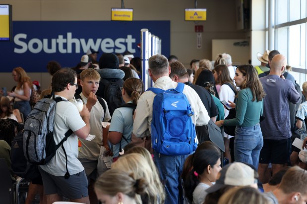 Southwest Airlines passengers surround boarding group posts for a flight at Midway International Airport, July 25, 2024, in Chicago. The company announced plans to change its boarding process to assigned seating, doing away with its 50-year policy of using boarding groups. (John J. Kim/Chicago Tribune)