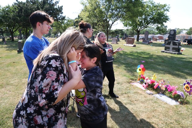 Melony Bustamante and her daughter, Julie, embrace while visiting the graves of Melony's sister, Amy Brown, and at St. Mary Catholic Cemetery in Evergreen Park on June 21, 2024. Brown was fatally stabbed during what police described as a domestic-related altercation in the Back of the Yards neighborhood on June 26, 2022. (Terrence Antonio James/Chicago Tribune)