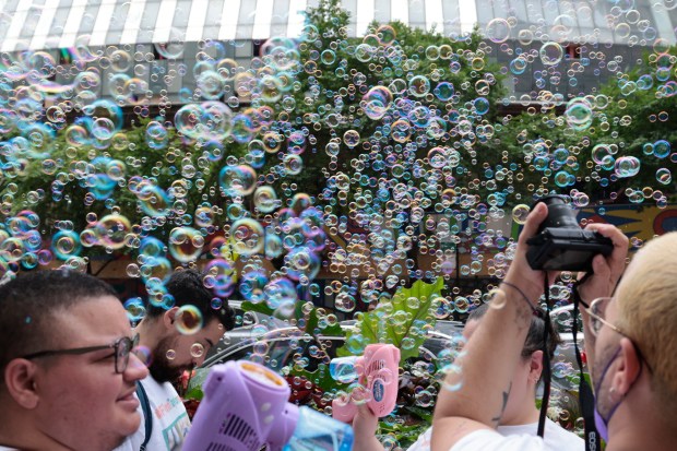 Bubbles are released in celebration of missing person Taylor Casey's birthday as family and friends rally outside Chicago City Hall, July 11, 2024. Casey disappeared in the Bahamas in June. (Antonio Perez/Chicago Tribune)