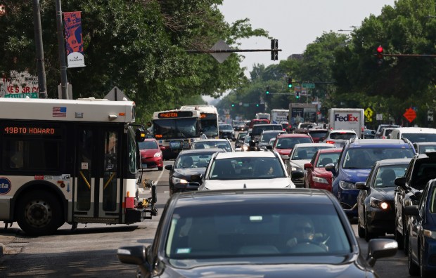 A No. 49 Western bus pulls out of the CTA Western Brown Line station into afternoon traffic as a pair of buses approach in the 4600 block of North Western Avenue on June 19, 2024, in Chicago. (John J. Kim/Chicago Tribune)