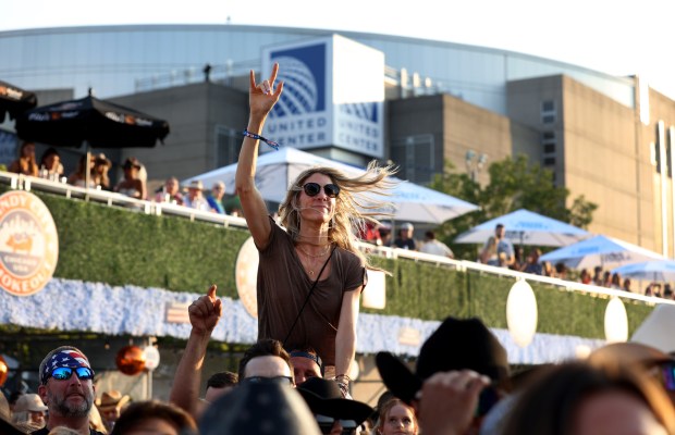 A fan watches as Lee Brice performs at the annual Windy City Smokeout outside of the United Center in Chicago on Friday, July 12, 2024. (Chris Sweda/Chicago Tribune)