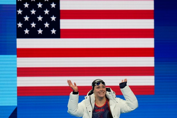 Katharine Berkoff, of the United States, waves as she walks onto the pool deck for her women's 100-meter backstroke final at the 2024 Summer Olympics, Tuesday, July 30, 2024, in Nanterre, France. (AP Photo/Petr David Josek)