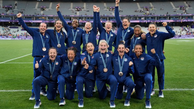 Members of the United States Rugby Sevens team pose for the media with their bronze medals after the medals ceremony at the 2024 Summer Olympics, in the Stade de France, in Saint-Denis, France, Tuesday, July 30, 2024. (AP Photo/Vadim Ghirda)