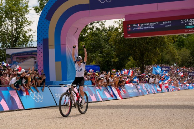 Haley Batten, of United States, crosses the finish line to win the silver medal in the women's mountain bike cycling event, at the 2024 Summer Olympics, Sunday, July 28, 2024, in Elancourt, France. (AP Photo/George Walker IV)