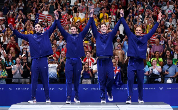 Gold Medalists, Jack Alexy, Chris Guiliano, Hunter Armstrong and Caeleb Dressel of Team United States acknowledge the fans during the Medal Ceremony after the Men's 4x100m Freestyle Relay Final on day one of the Olympic Games Paris 2024 at Paris La Defense Arena on July 27, 2024 in Nanterre, France. (Photo by Maddie Meyer/Getty Images)