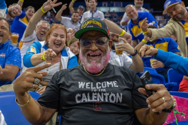 A Gigantes de Carolina fan sits amid Bayamón Vaqueros' fans, during a basketball game between Bayamon and the Guaynabo Mets, at the Ruben Rodríguez Coliseum in Bayamón, Puerto Rico, Monday, July 1, 2024. Puerto Rico's professional basketball league is experiencing a renaissance thanks to reggaeton stars like Bad Bunny, Ozuna and Anuel AA, who are stepping into the financial game, buying local teams and helping to stack up a loyal fan base. (AP Photo/Alejandro Granadillo)