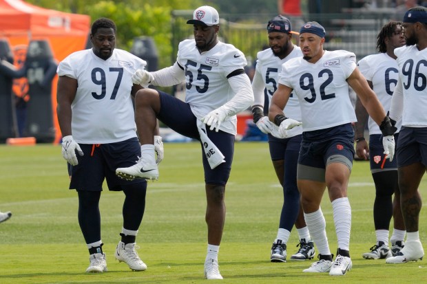 Bears defensive end Jacob Martin (55) warms up as defensive tackle Andrew Billings (97) and defensive end Daniel Hardy (92) look on during training camp in Lake Forest on July 23, 2024. (AP Photo/Nam Y. Huh)