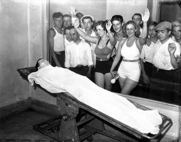 Betty Nelson and Rosella Nelson view the body of John Dillinger while in bathing suits at the Cook County morgue in Chicago. In the days after Dillinger was killed on July 22, 1934, massive crowds lined up outside the morgue to get a glimpse of the notorious public enemy. (Chicago Tribune historical photo)