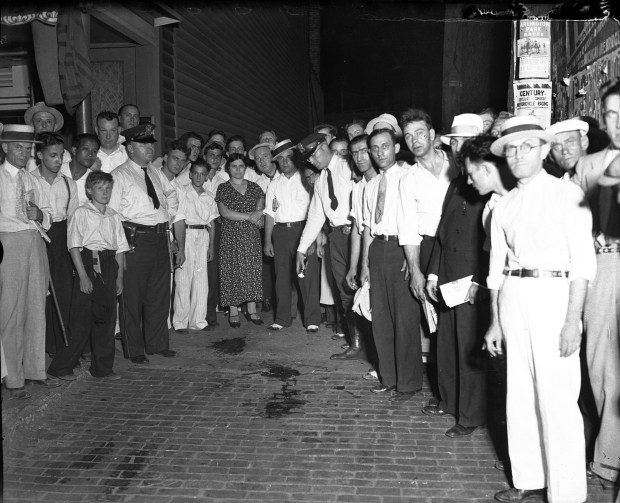 A crowd gathers around the blood stain from John Dillinger in the alley behind the Biograph Theater in Chicago in 1934. (Chicago Tribune historical photo)