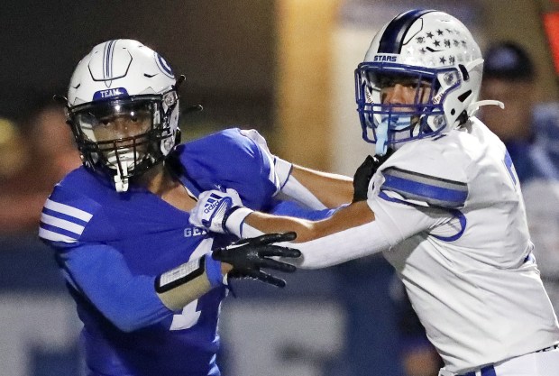 Geneva receiver Talyn Taylor (1) tries to elude St. Charles North's Alexander Valenzuela (8) on Friday, Sept. 23, 2022.