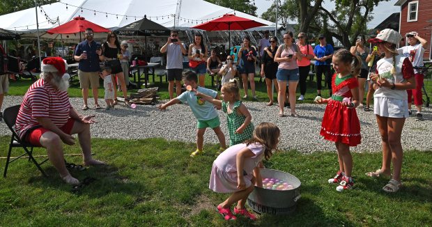 Santa Claus is getting pelted with mini water balloons at Christmas in July at Brothers' Field in downtown Long Grove on July 13, 2024. (Karie Angell Luc/Lake County News-Sun)