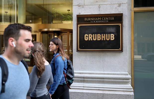 People pass by the offices of Grubhub, located at the Burnham Center in Chicago in 2019.