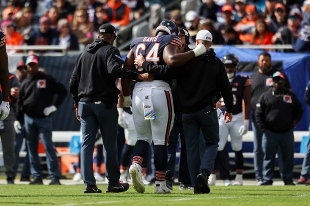 Bears guard Nate Davis is helped off the field in the first quarter against the Vikings on Oct. 15, 2023, at Soldier Field.