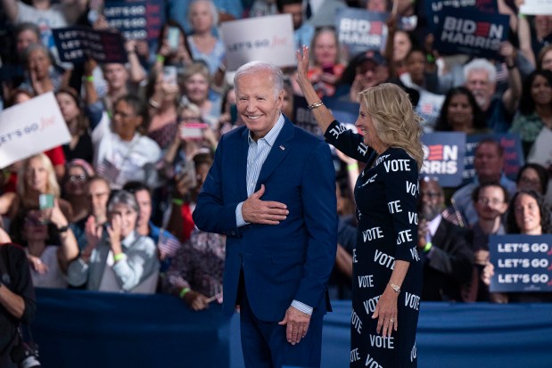 President Joe Biden and first lady Jill Biden, with "Vote" printed on her dress, gesture to supporters during a campaign rally on Friday, June 28, 2024, in Raleigh, North Carolina. (Allison Joyce/Getty Images/TNS)