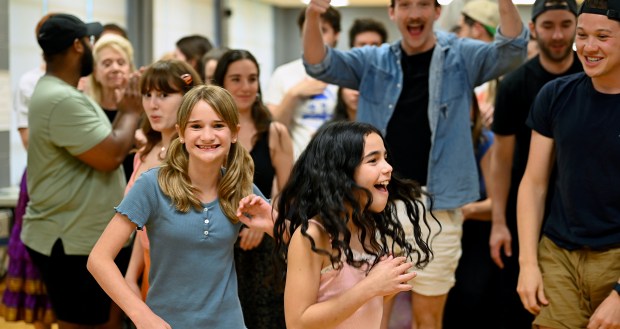 Front row, from left, Lanah Vurnakes, 11, a rising sixth-grader of Glenview and Brielle Horwitch, 10, a rising fifth-grader of Northbrook emerge with joy from a group photo session on Sunday, July 7, 2024 after a West Ridge Center (636 W. Ridge Road) rehearsal in Highland Park of Les Misérables by the Uptown Music Theater of Highland Park. (Karie Angell Luc/Pioneer Press)