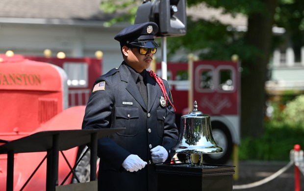 Mike De Leon, Evanston firefighter, has the task of sounding the silver bell at the July 22, 2024 First Responder Remembrance Ceremony at Firemen's Park in Evanston. (Karie Angell Luc/Pioneer Press)