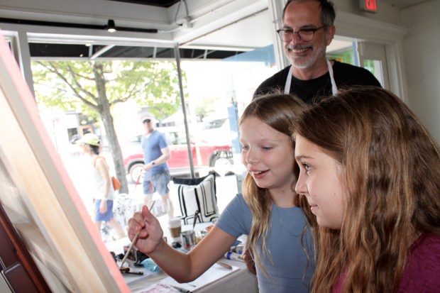 11-years-old Wilmette residents Catherine Shedivy and Blake Hartman receive an impromptu art lesson from Patrician Gallery Houston based artist Andy Dearwater during the village's Sidewalk Sale. (Gina Grillo/Pioneer Press)