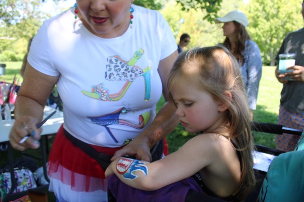 Scarlet England age 3, of Wilmette selects a flaming baseball tattoo during Star Spangled Splash hosted by the Wilmette Park District on July 3. (Gina Grillo/Pioneer Press)