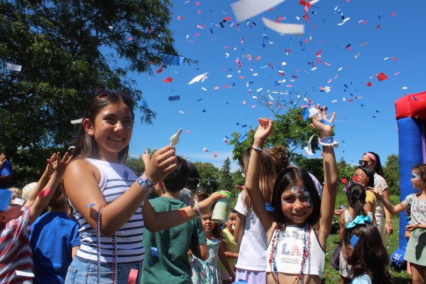 Wilmette residents Mia Ramirez, age 12, and Emma Ramirez, age 9, enjoy the confetti fireworks display during Star Spangled Splash. (Gina Grillo/Pioneer Press)