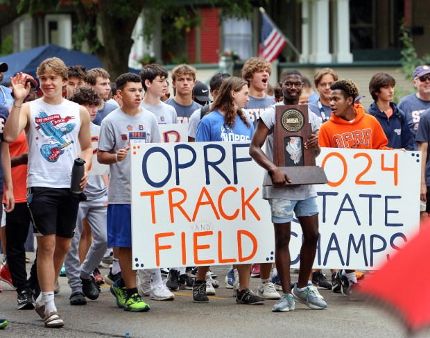 OPRF high school track and field team with the state trophy during the annual Independence Day Parade Thursday, July 4, 2024, in Oak Park. (James C. Svehla/for Pioneer Press)