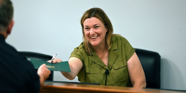 Right, Northbrook Village President Kathryn L. Ciesla hands a proclamation to Northbrook Police Chief Christopher Kennedy during the Northbrook Board of Trustees meeting on July 23, 2024. (Karie Angell Luc/Pioneer Press)