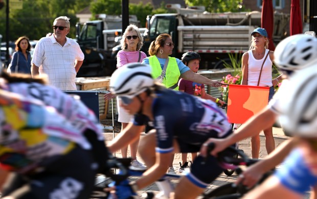 With the flag on Shermer Road at Meadow Road is crossing guard volunteer Mary Bleeker of Northbrook at the Northbrook Grand Prix on July 25, 2024 in downtown Northbrook. (Karie Angell Luc/Pioneer Press)