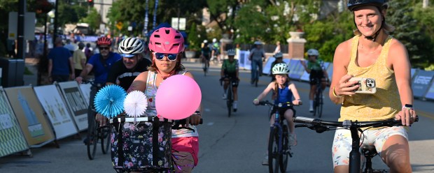 With the pink balloon is Amelia Edson, 10, a rising fifth-grader from Northbrook, riding on Shermer Road during Bike the Green at the Northbrook Grand Prix on July 25, 2024 in downtown Northbrook. (Karie Angell Luc/Pioneer Press)