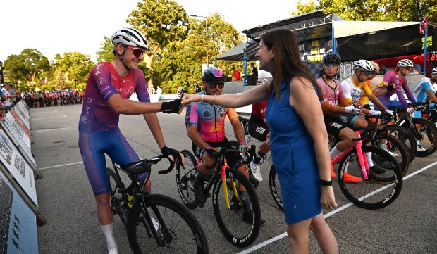 Right, on Shermer Road, Illinois State Rep. 57th District Tracy Katz Muhl of Northbrook recognizes cyclists before the start of the last race of the day, the Garner Cyclery Men Pro Cat 1/2 at the Northbrook Grand Prix on July 25, 2024 in downtown Northbrook. (Karie Angell Luc/Pioneer Press)