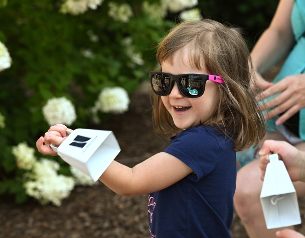 From left, Eleanor Walters, 2, and her brother Henry, 5, a rising kindergartner of Northbrook, ring cowbells at the Northbrook Grand Prix on July 25, 2024 in downtown Northbrook. (Karie Angell Luc/Pioneer Press)