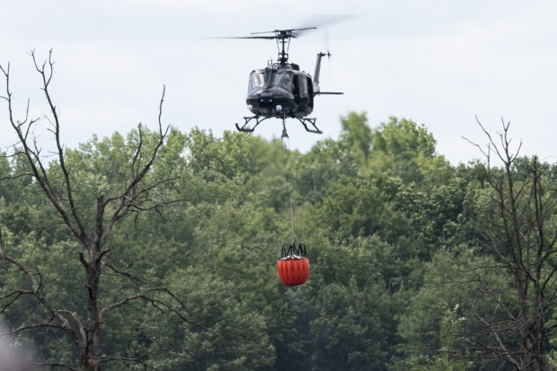 A Lake County Sheriff's Department helicpter carries water from a nearby lake with a Bambi Bucket, used to scoop water from ground water sources to douse fires, during a demonstration at Griffith Airport on Thursday, July 18, 2024. (Kyle Telechan/for the Post-Tribune)