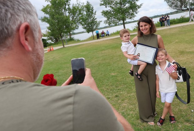 Mrs.Slavica Gjorewski stands with her children, Luka 2, Andrej 6, as her husband Ivanco takes a photo after the naturalization of 50 people from 23 countries by federal Magistrate Judge Abizer Zanzi at the Pavilion at Wolf Lake in Hammond on Wednesday, July 3, 2024. (John Smierciak/for the Post Tribune.