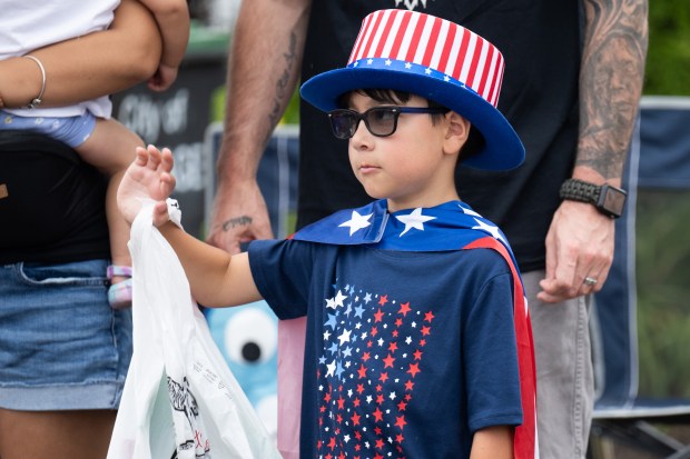 Portage resident Austion Moreau, who won his costume in a rock, paper, scissors contest at Aylesworth Elementary, waves to parade participants along Willowcreek road during the City of Portage 4th of July Parade on Thursday, July 4, 2024. (Kyle Telechan/for the Post-Tribune)