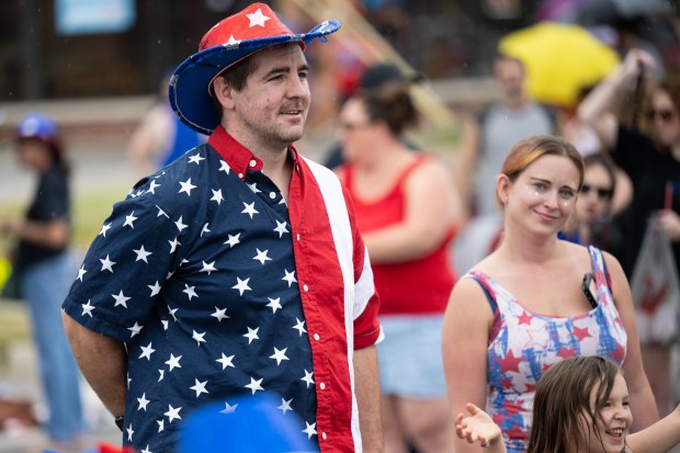 Portage resident Mike Manning, on left, enjoys the Portage 4th of July parade with his wife Liz, and daughter Eva, 5, on Thursday, July 4, 2024. (Kyle Telechan/for the Post-Tribune)