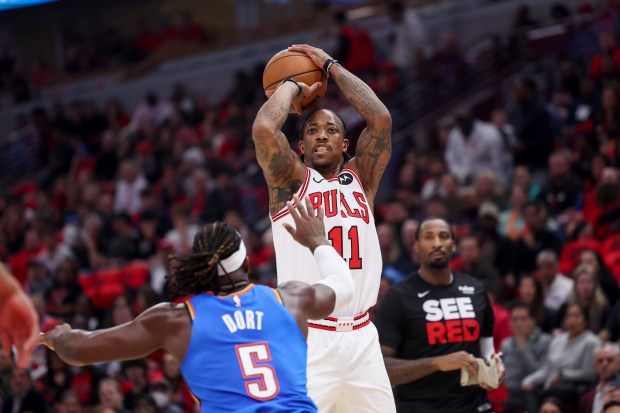 Bulls forward DeMar DeRozan shoots a 3-pointer over Thunder guard Luguentz Dort during the first quarter of the season opener at the United Center on Oct. 25, 2023.