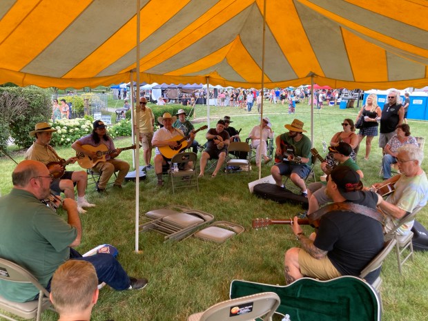 String players of all ages gather Sunday, July 14, in the Picker's Tent to play bluegrass standards at the 2024 Frankfort Bluegrass Festival. (Paul Eisenberg/Daily Southtown)